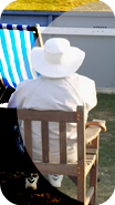 Picture of a man in a hat sitting at a cricket match.